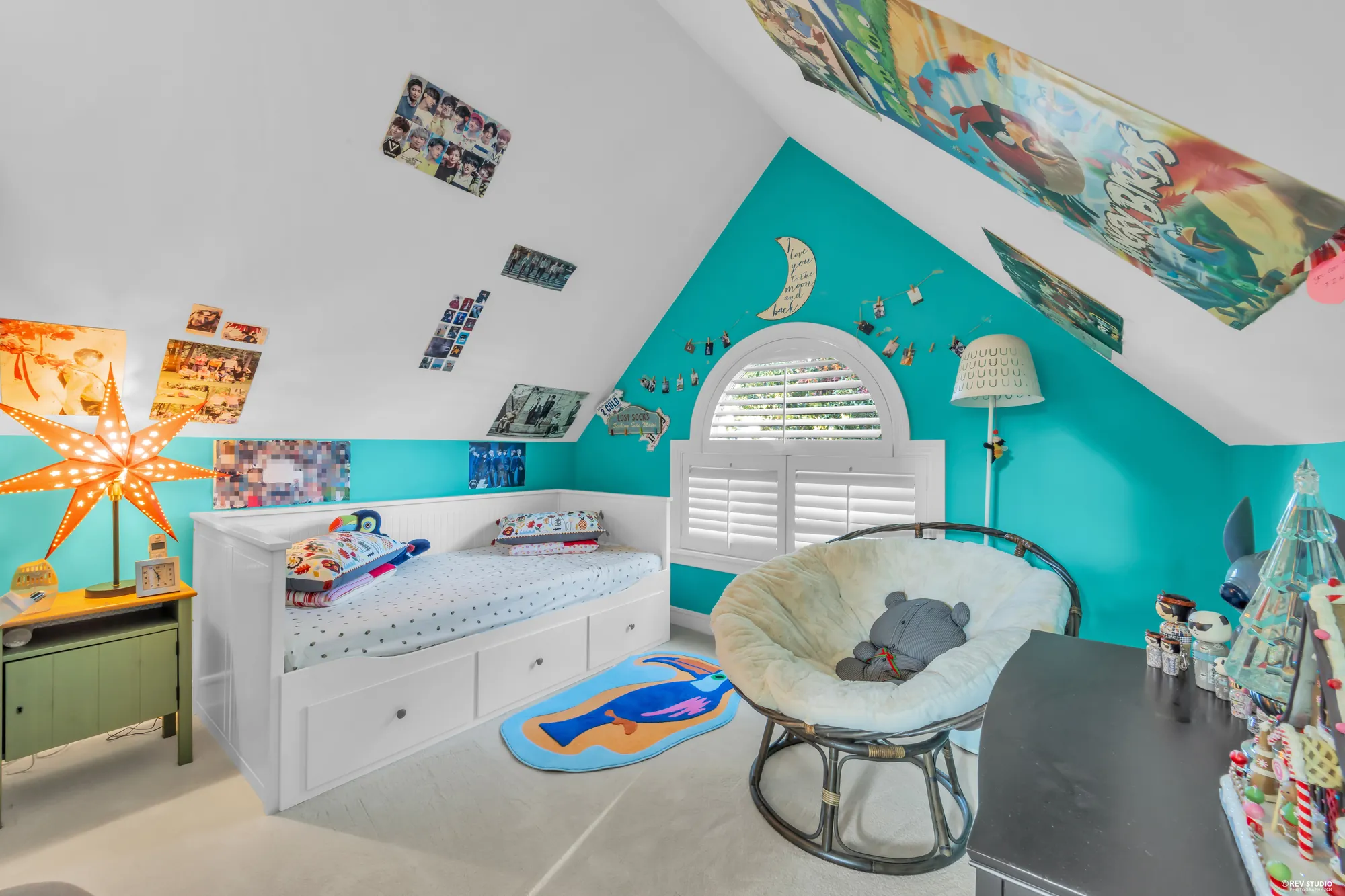 The same bedroom toward its window, the daybed and a round chair