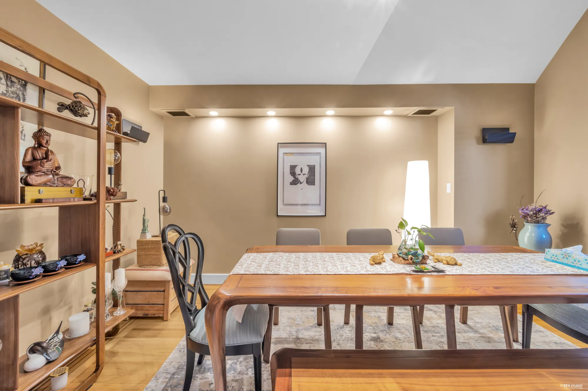 The dining room from the window end: the table, a wooden shelving unit, the doors to the foyer